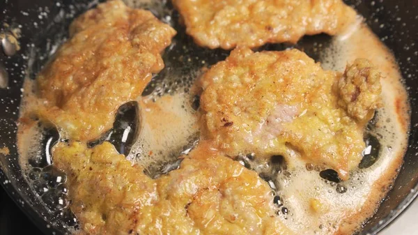 Fry meat in oil in frying pan. Fatty foods, close-ups.