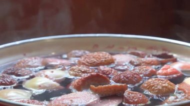 Meyve içeceği hazırlama işlemi. Meyve dilimleri kaynar suda kaynatılır, buhar yüzeyde yükselir..