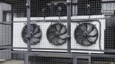 Air conditioning and ventilation system. Three large rotating fans behind barrage grille.