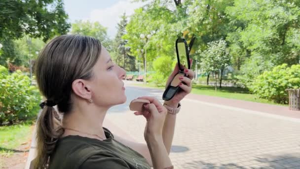Middle Aged Woman Adjusts Makeup Her Face She Sits Park — Vídeo de Stock