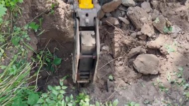 Operation of jackhammer located on excavator. Mechanical equipment for digging trenches.