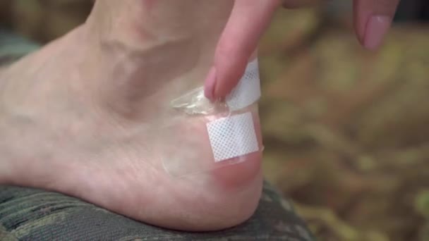 Una Mujer Aplica Yeso Médico Una Herida Talón Debido Zapatos — Vídeo de stock