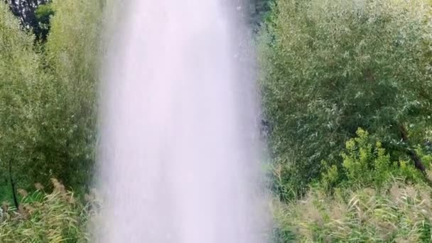 緑の自然を背景にさまざまな方向に飛ぶ噴水のスプレー — ストック動画