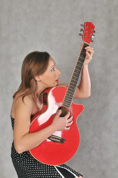 Funny girl s červenou kytarou — Stock fotografie