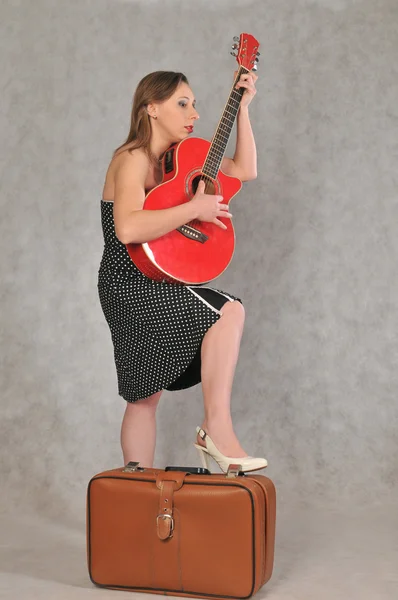 Menina em um vestido de bolinhas tocando guitarra — Fotografia de Stock