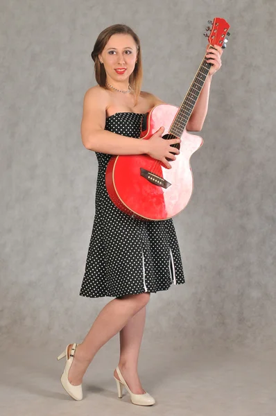 Lustiges Mädchen mit roter Gitarre — Stockfoto