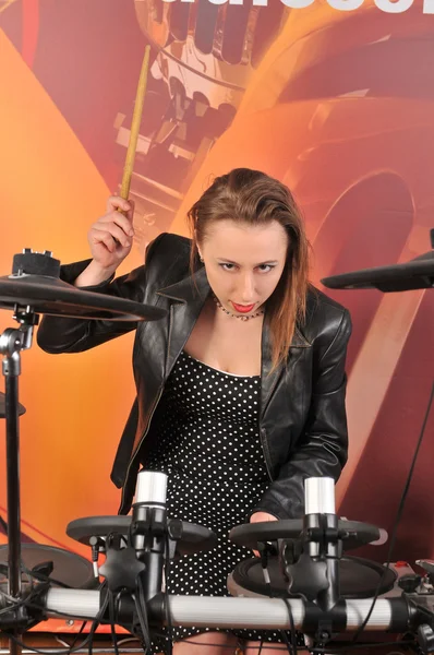 Jeune femme en robe à pois et veste jouant de la batterie — Photo