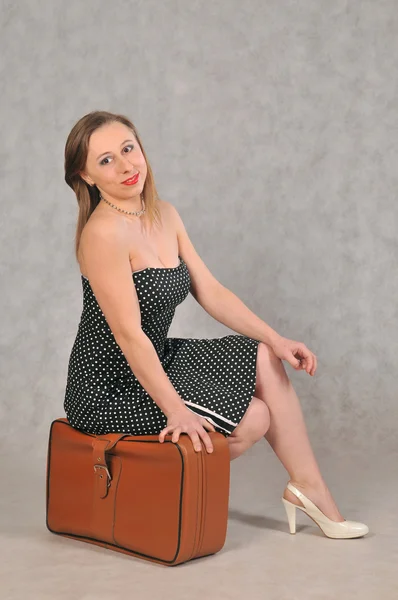 Vrolijk meisje met een retro koffer — Stockfoto