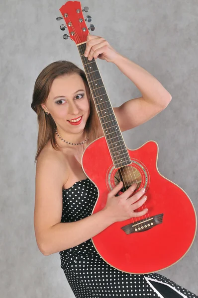 Cheerful girl with a red guitar — Stock Photo, Image