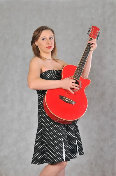 Cheerful girl with a red guitar — Stock Photo, Image