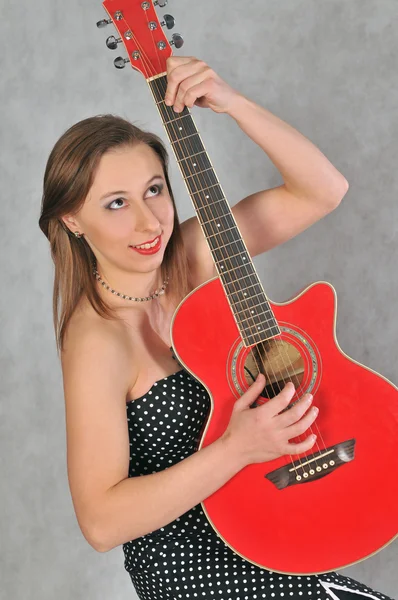 Una ragazza suona la chitarra rossa — Foto Stock