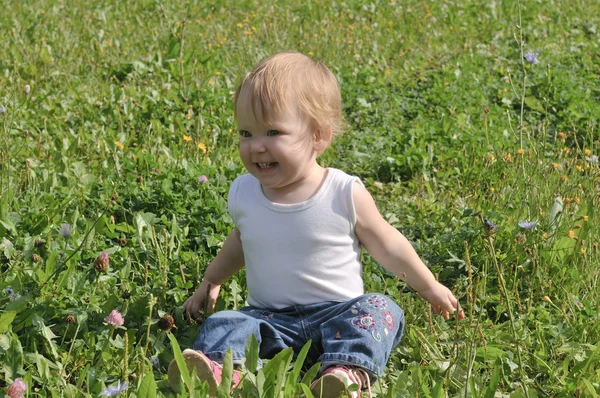 Little one-year-old girl sitting on the summer glade — Stock Photo, Image