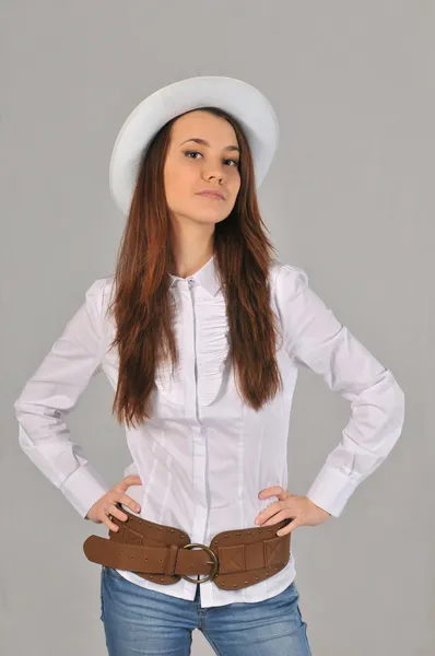 Girl bend his back in a white blouse and jeans with hands on hips — Stock Photo, Image