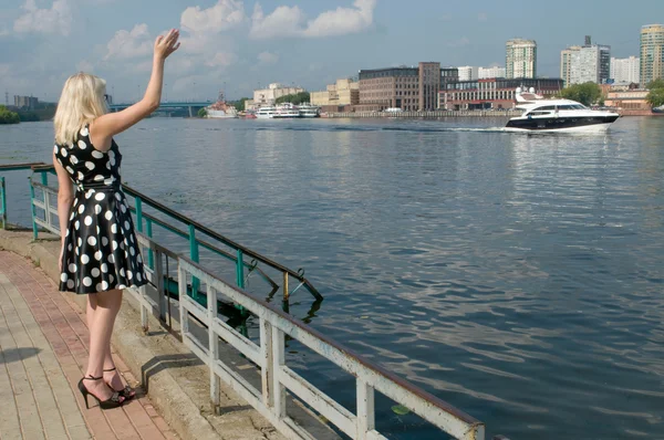 Das Mädchen am Ufer des Khimki-Stausees winkt mit dem Segelboot — Stockfoto
