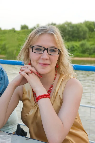 Szczęśliwy uśmiechający się blondynka siedzi na pokładzie statku rzeki — Zdjęcie stockowe