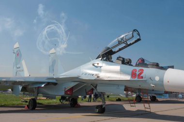 Zhukovsky, RUSSIA - 29 Ağustos 2019: Rus süpersonik iki koltuklu avcı uçağı Sukhoi Su-30 CM Flanker-C MAKS-2019 hava gösterisindeki akrobatik grup uçak uçağının arka planında