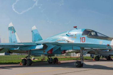 Zhukovsky, RUSSIA - 29 Ağustos 2019: Rus süpersonik Sukhoi Su-34 Fullback savaş uçağı bombacısı MAKS-2019 hava gösterisinde bir akrobatik uçak grubunun arka planında