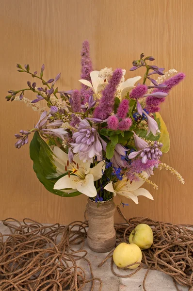 Stilleven bouquet van hemerocallis en astilbe met touw en appels — Stockfoto