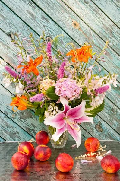 Still life bouquet of lily, hosta, astilbe, hemerocallis, pink hydrangea and nectarines. — Stock Photo, Image