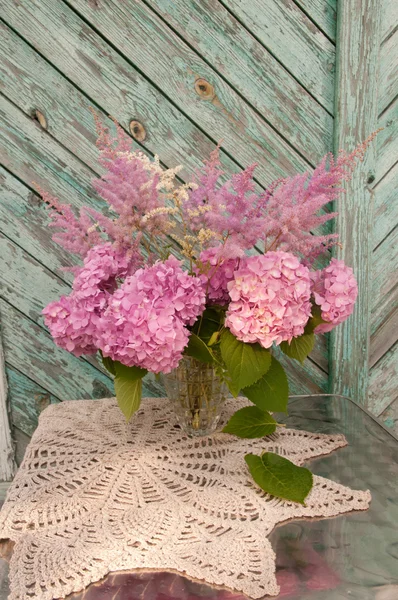 Still life bouquet with pink hydrangea and astilba on the old chair with crochet tablecloth — Stock Photo, Image