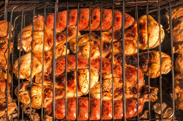 Griller les cuisses de poulet, les petites saucisses et la viande — Photo