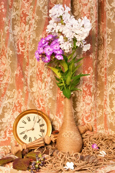 Zátiší kytice phlox a starožitné hodiny — Stock fotografie