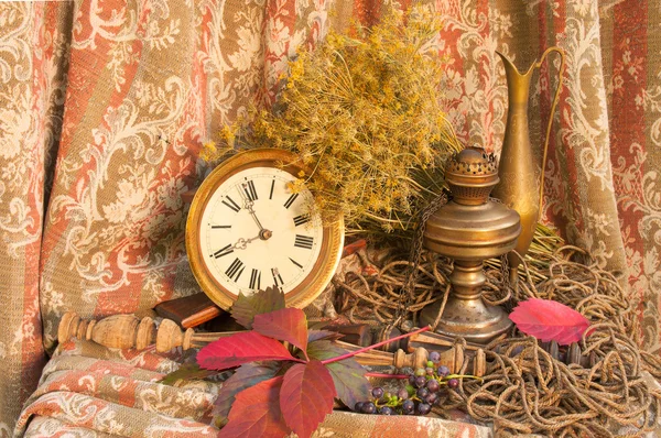 Autumnal still life with clock and oil lamp — Stock Photo, Image