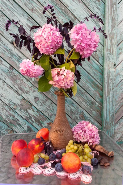 Buquê de natureza morta com flores de hortênsia rosa e pêssegos — Fotografia de Stock