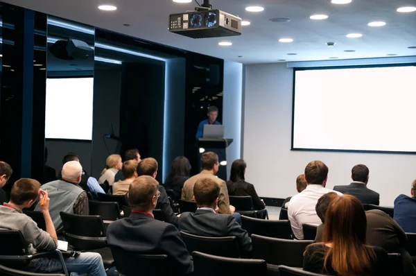 Obchodní konference. lidé sedí vzadu a reproduktor na obrazovce — Stock fotografie