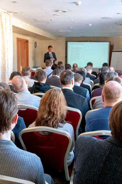 Les gens assis à l'arrière à la conférence d'affaires et le haut-parleur à l'écran — Photo