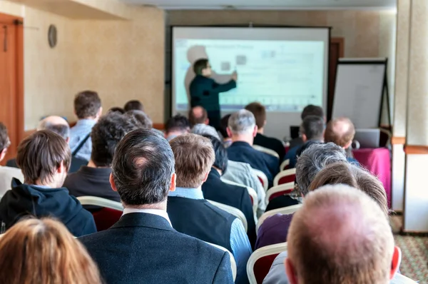 Business conference. people sitting rear and speaker explaining — Stock Photo, Image