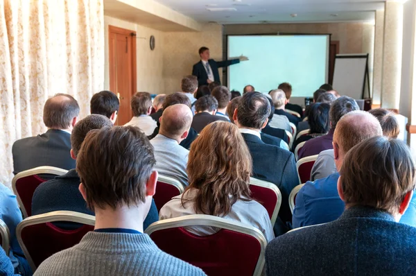 Conférence d'affaires. personnes assises à l'arrière et haut-parleur expliquant à l'écran — Photo