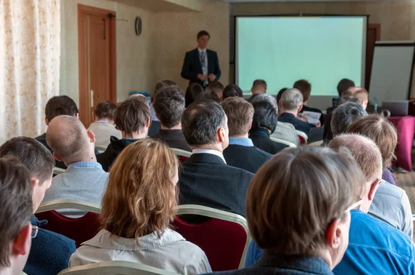 Menschen auf dem Business-Seminar und Redner am Bildschirm — Stockfoto