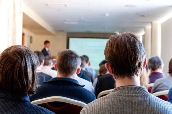 Emberek ülnek a hátsó az üzleti konferencia — Stock Fotó