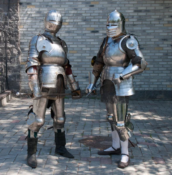 Dois cavaleiros na antiga armadura de metal perto da parede de pedra — Fotografia de Stock