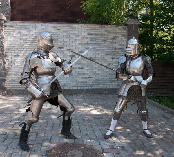 Two knights in the ancient metal armor standing near the stone wall — Stock Photo, Image