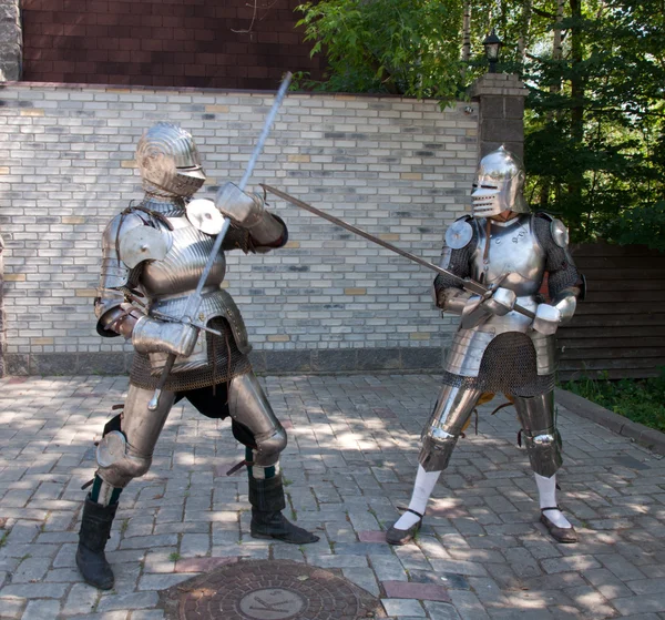 Two knights in the ancient metal armor standing near the stone wall — Stock Photo, Image