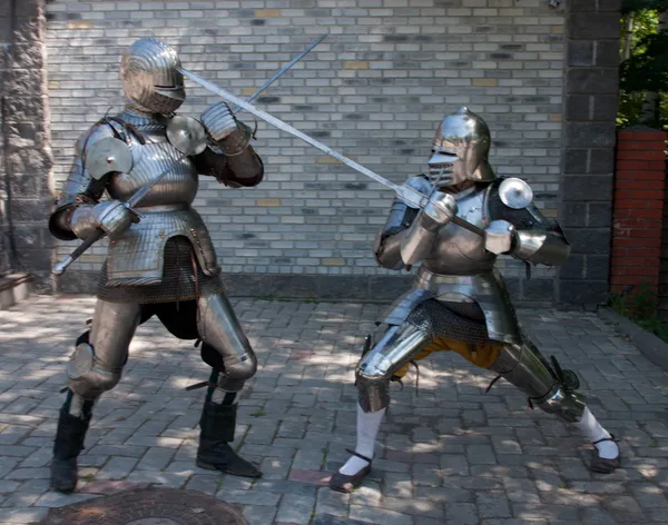 Two knights in the ancient metal armor standing near the stone wall — Stock Photo, Image