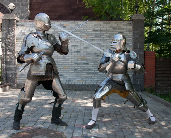 Two knights in the ancient metal armor standing near the stone wall — Stock Photo, Image