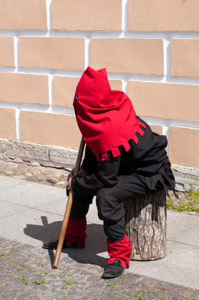 Executioner sitting near the wall on the street — Stock Photo, Image