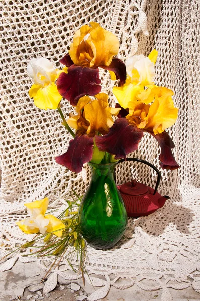 Profumo di nature morte con iridi rare gialle e marroni in vaso verde e teiera — Foto Stock
