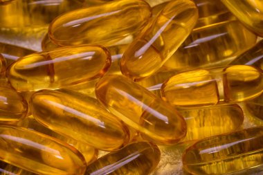 Arka plan dokusu olarak Omega-3 balık yağı kapsülleri. EPA ve DHA vücudumuzun günlük olarak ihtiyaç duyduğu temel yağ maddeleridir..