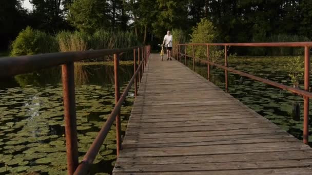 Radfahrer läuft über Brücke — Stockvideo