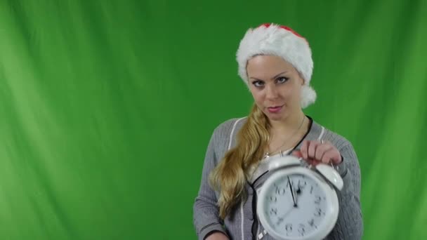 Beautiful young girl in santa claus hat with a alarm. — Stock Video