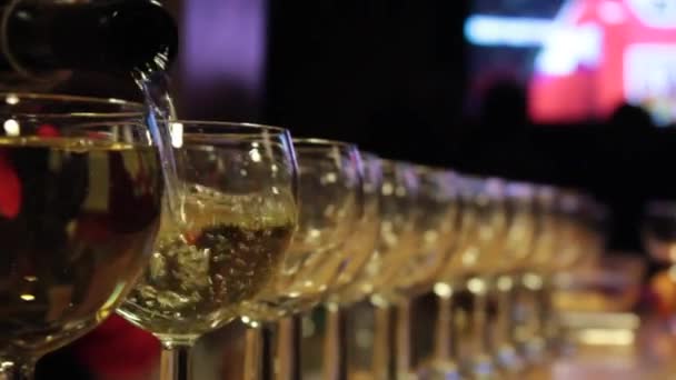 Celebration match. White wine pouring in many glasses. — Stock Video