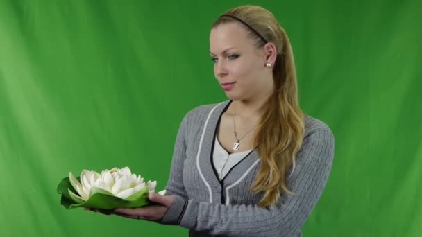 若い女の子の顔に白い睡蓮を保持笑みを浮かべて、緑色の画面上に分離。no.03 — ストック動画