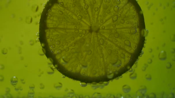 Lima en agua de soda sobre fondo verde — Vídeos de Stock
