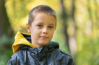 Ormanda kameraya gülümseyen bir çocuğun portresi..