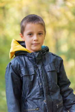 Ormanda kameraya gülümseyen bir çocuğun portresi..