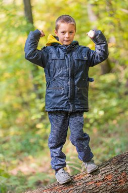 Ormanda kameraya gülümseyen bir çocuğun portresi..